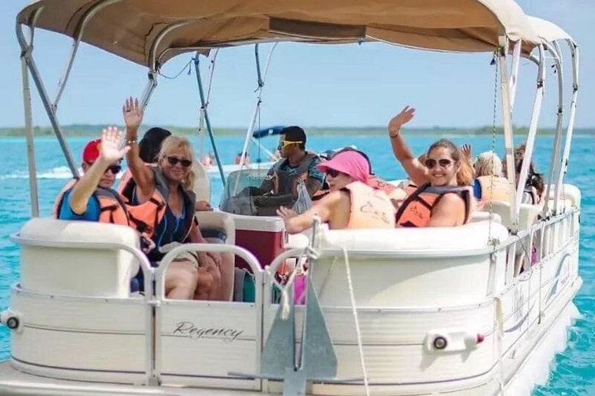 A boat with people wearing life jackets, a canopy, and the word 'Reyco' on the side. 3