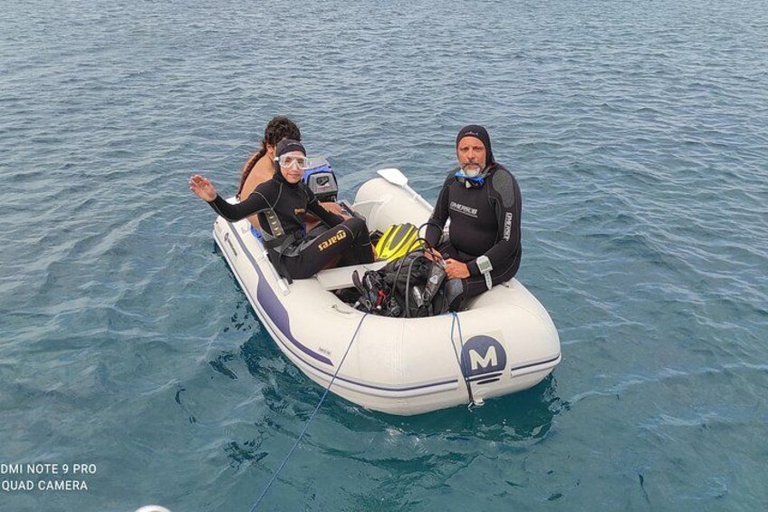Two people on a white inflatable boat with a motor, floating on calm water. 2