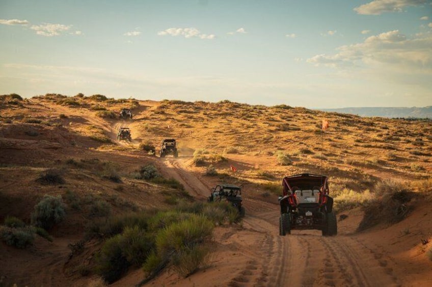 Off-road vehicles on a dirt path in a desert landscape. 2