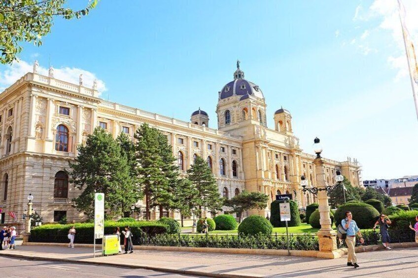 A large historic building with a dome and columns, surrounded by trees and a well-maintained garden. 5