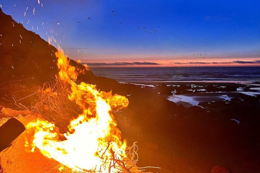 A mesmerizing sunset with birds soaring in the sky and a warm fire glowing below – a perfect moment of serenity and nature. 2