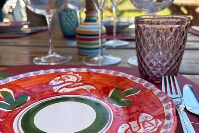 Une table dressée avec une assiette colorée, un verre et des couverts. 2