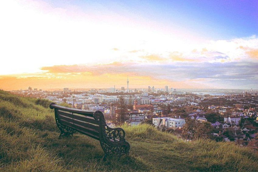 A bench overlooking a cityscape during sunset. 4