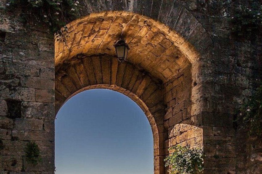 Un arco de piedra con un farol en la parte superior. 4