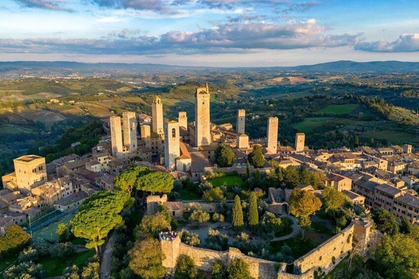 Un pueblo histórico con arquitectura medieval, incluyendo torres y una muralla fortificada. 3