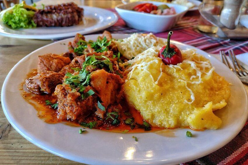 A plate of food with meat, vegetables, and a yellow dish, possibly a side or main course. 2