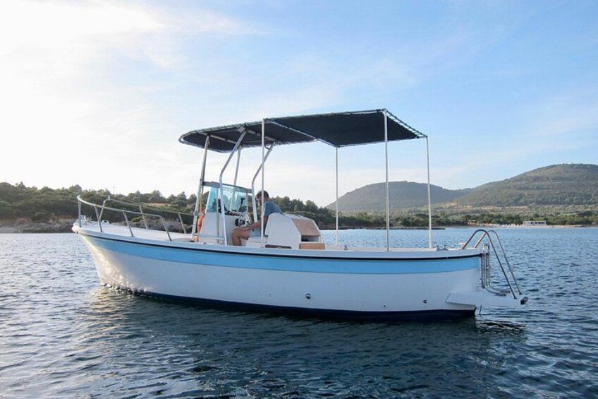 A small boat with a canopy on a calm lake surrounded by hills. 4
