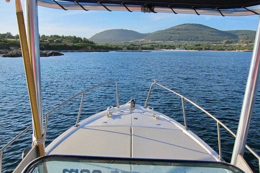 A boat on calm water with a view of a mountainous landscape in the distance. 2