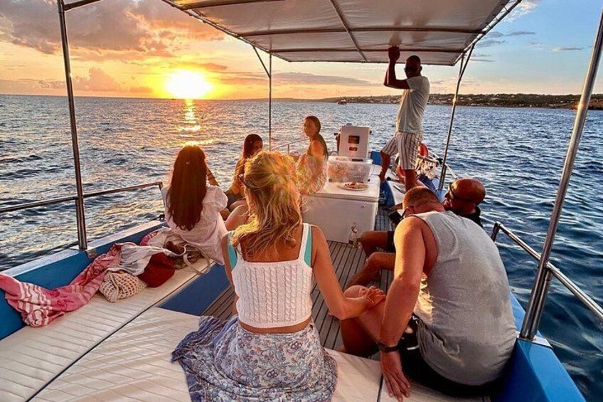 A group of people on a boat during sunset. 1