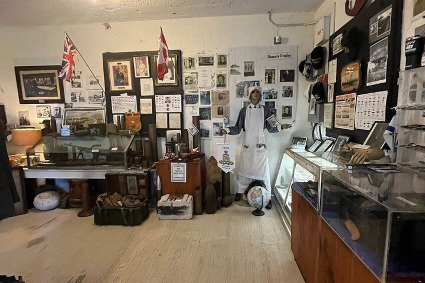 Tienda con diversos artículos a la vista, incluyendo banderas, cuadros enmarcados y un mostrador con una persona detrás. 4