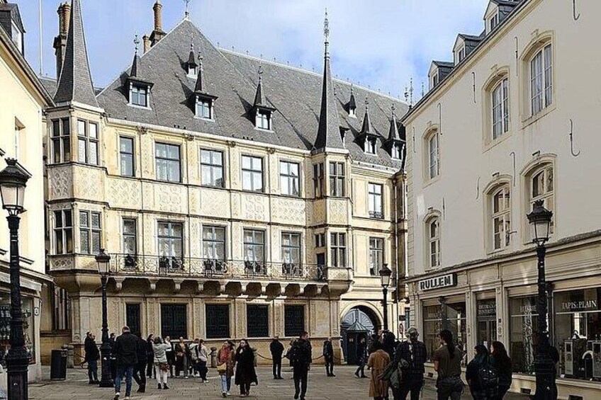 Un bâtiment historique à l’architecture riche et élaborée, et une foule de personnes rassemblées sur une place. 2