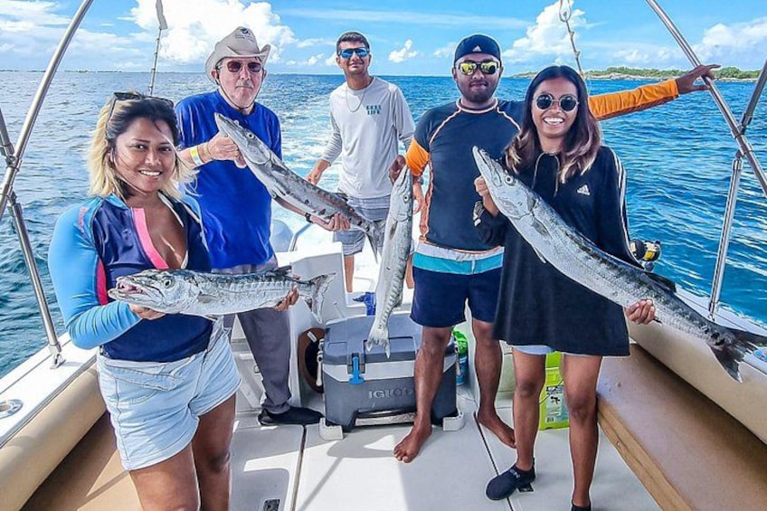 A group of people on a boat holding large fish. 5