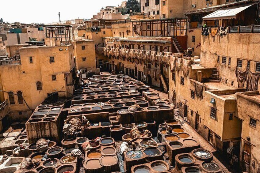 A traditional Moroccan medina with narrow streets, terracotta rooftops, and numerous clay pots. 4