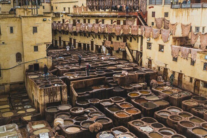 A traditional Moroccan tannering area with large basins and hanging cloths. 3