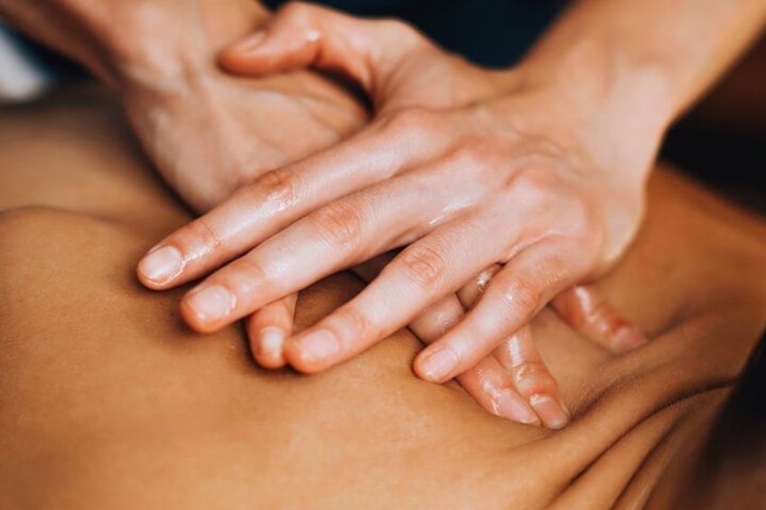 Hands performing a massage on a person's back. 4