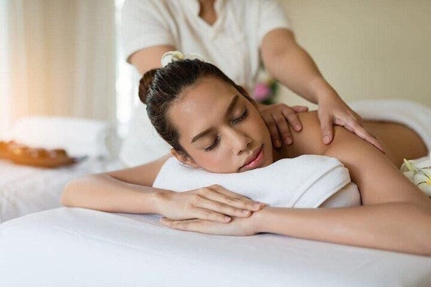 A person receiving a massage on a white massage table. 2