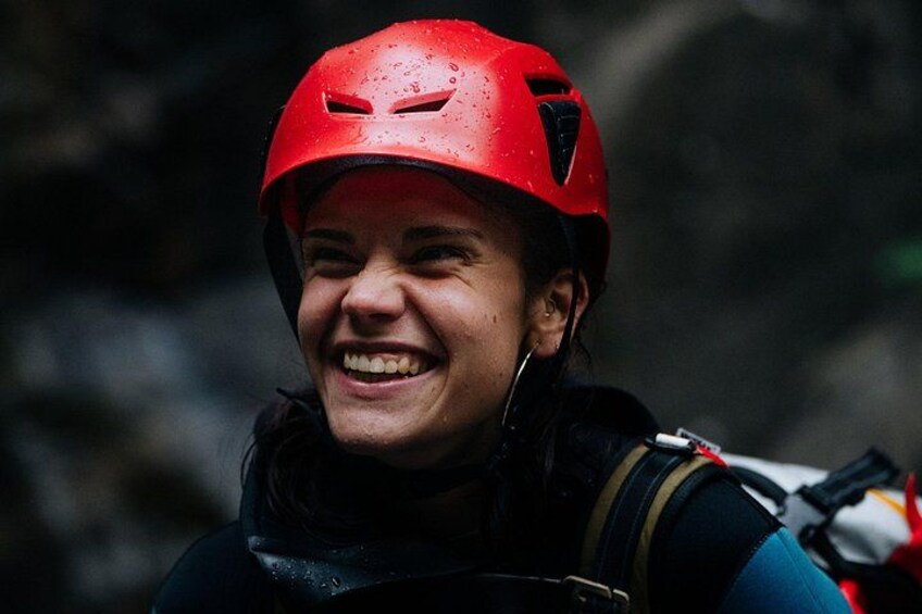 A person wearing a red helmet and a blue jacket with a backpack. 2