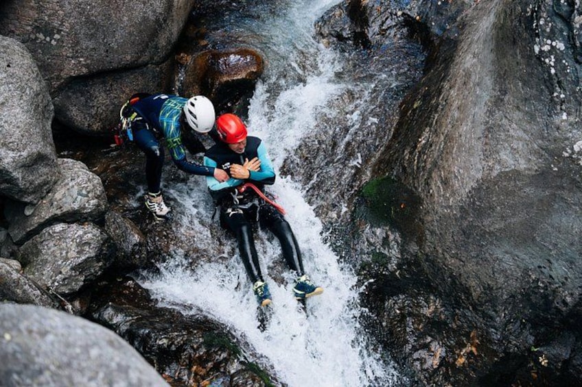 Two people rappelling down a rocky waterfall. 1