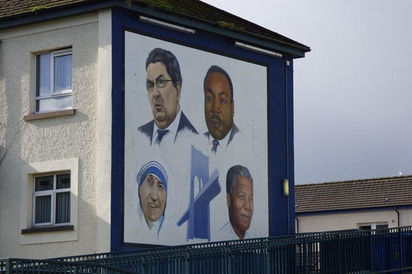 A mural on a building with four portraits. 4