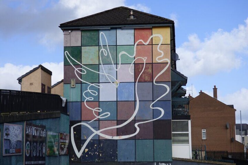 A colorful building with a mural of a hand and abstract shapes. 3