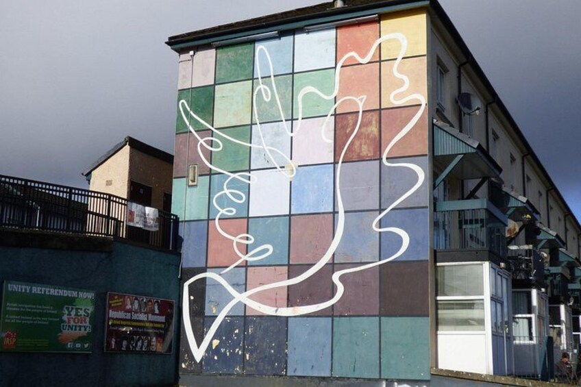 A building with a colorful mosaic and a white abstract design on the facade. 5