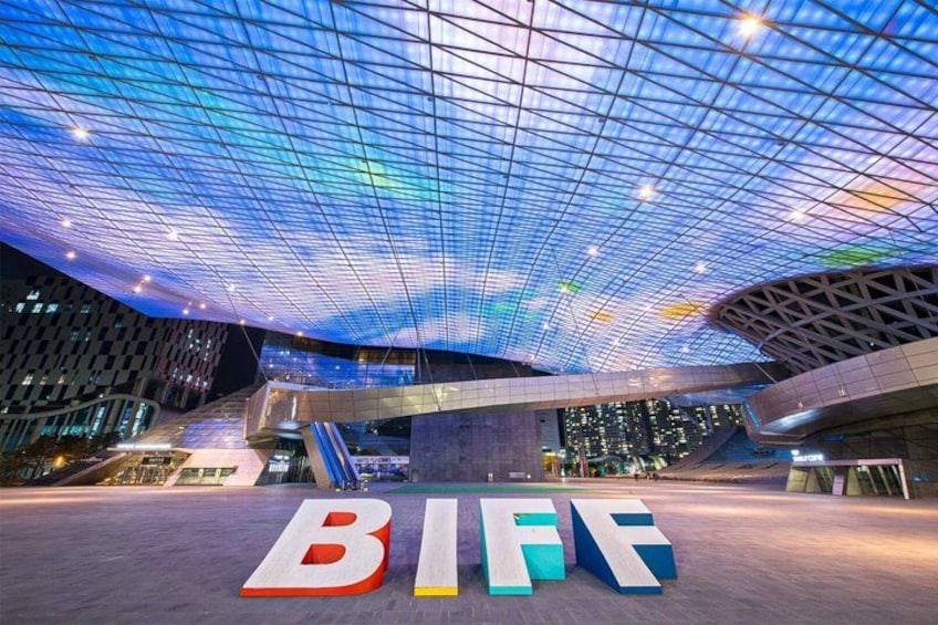 Una estructura arquitectónica moderna con techo de vidrio y letras iluminadas que deletrean 'BIF'. 2
