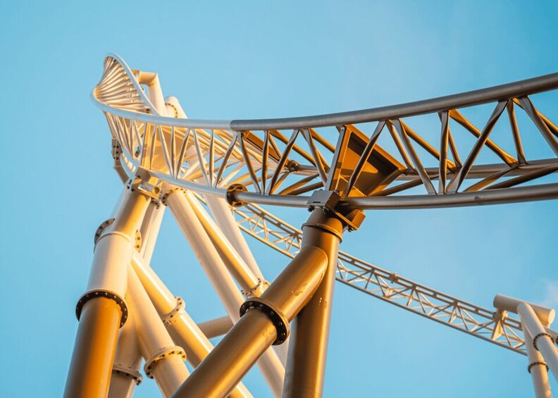 A roller coaster track with a clear blue sky in the background. 2