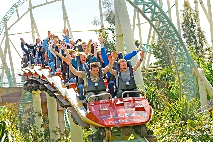 A roller coaster at Colossus Park with riders in blue jackets. 3