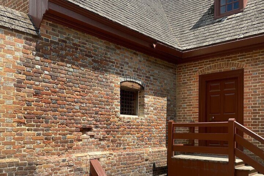 Un bâtiment en briques avec une porte et une fenêtre en bois. 5