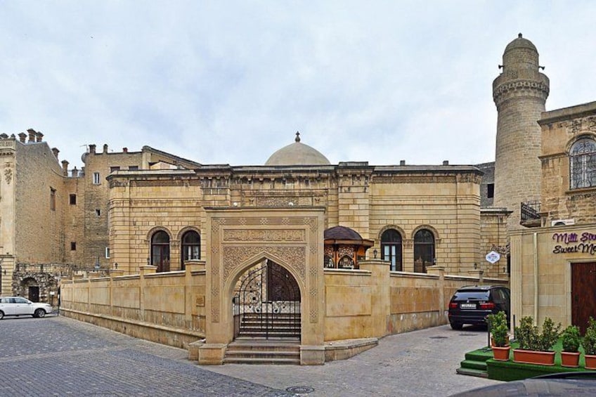 Ein historisches Gebäude mit einem großen Rundbogenportal, einer Kuppel und einem Minarett. 4