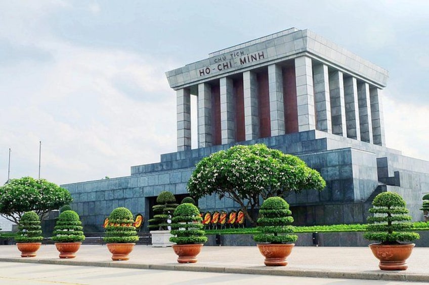 Un edificio con columnas y un cartel que dice 'HO CHI MINH'. 1