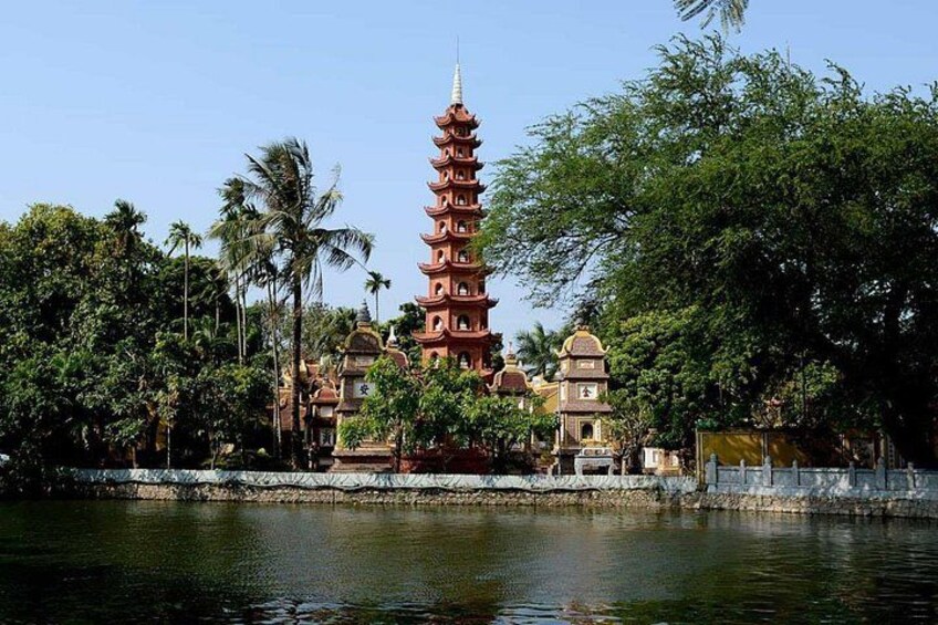 Una torre al estilo pagoda, una masa de agua y follaje circundante. 2