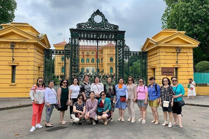Un grupo de personas posando frente a un edificio histórico con puertas ornamentales. 5