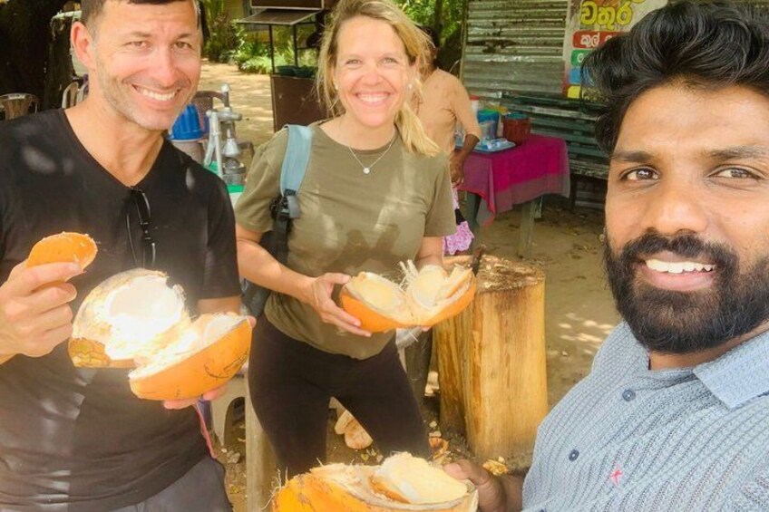 Tres personas sosteniendo pan con cubiertas de coco, de pie al aire libre con un fondo rústico. 2