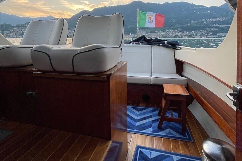 Interior de un barco con asientos, una mesita y una bandera. 5