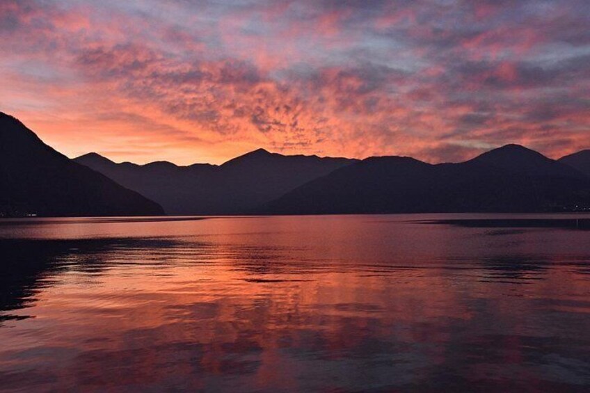 Un lago al atardecer con montañas al fondo. 3