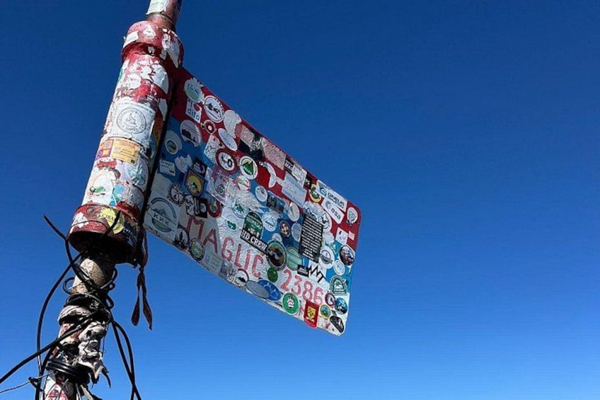 Ein Pfosten, der mit bunten Aufklebern versehen ist, vor blauem Himmel. 2
