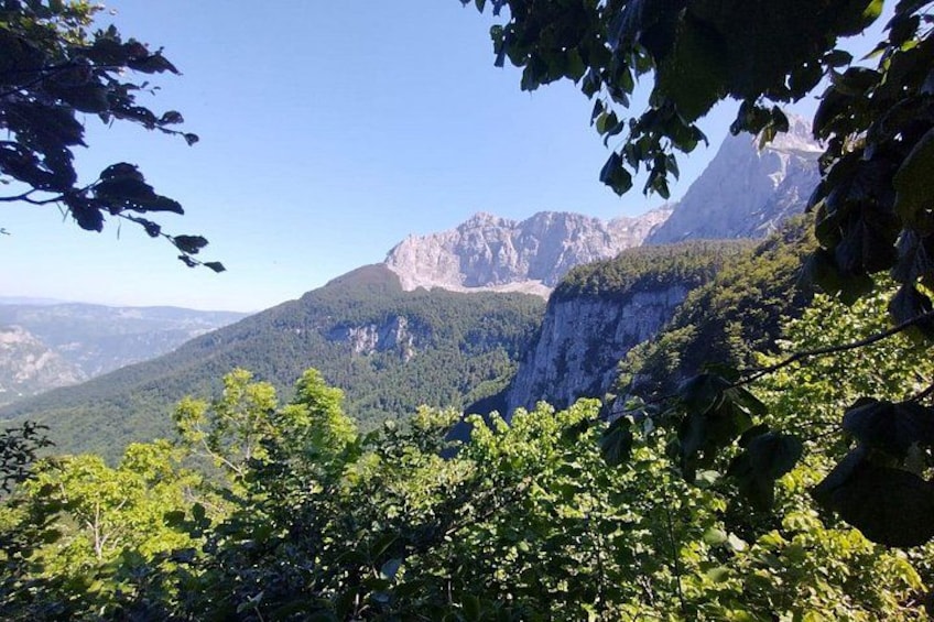 Eine Berglandschaft mit dichtem Grün und steilen Felsen. 1