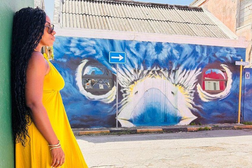 Un mural con un diseño azul y blanco, un vestido amarillo y una señal azul. 3