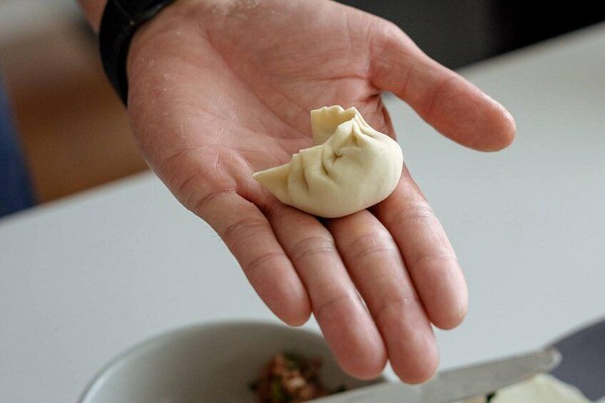 A hand holding a dumpling. 5