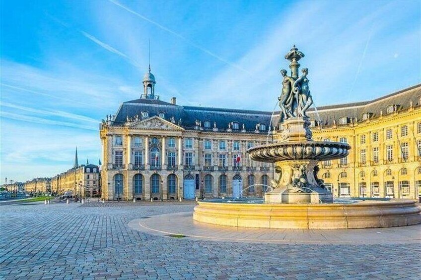 A historic building with a large fountain in front. 3