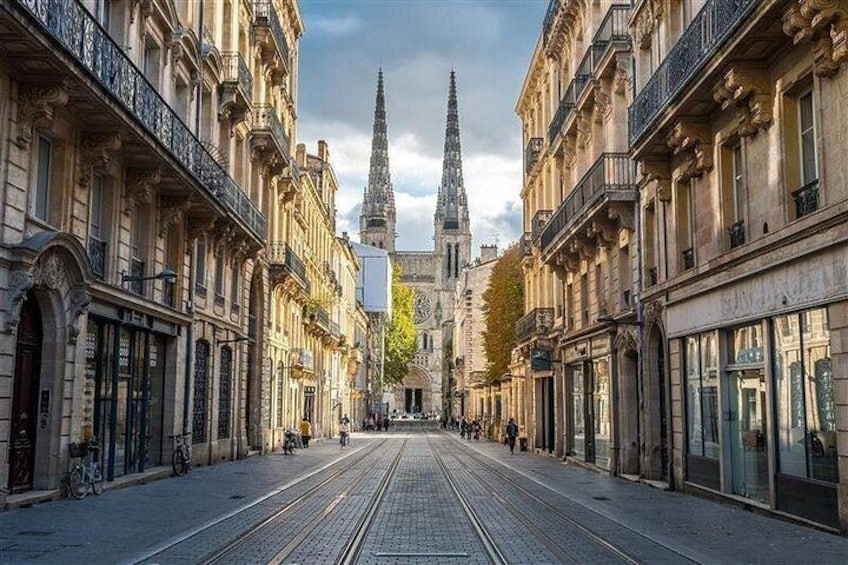 A street with buildings, a tram track, and a church spire in the distance. 2