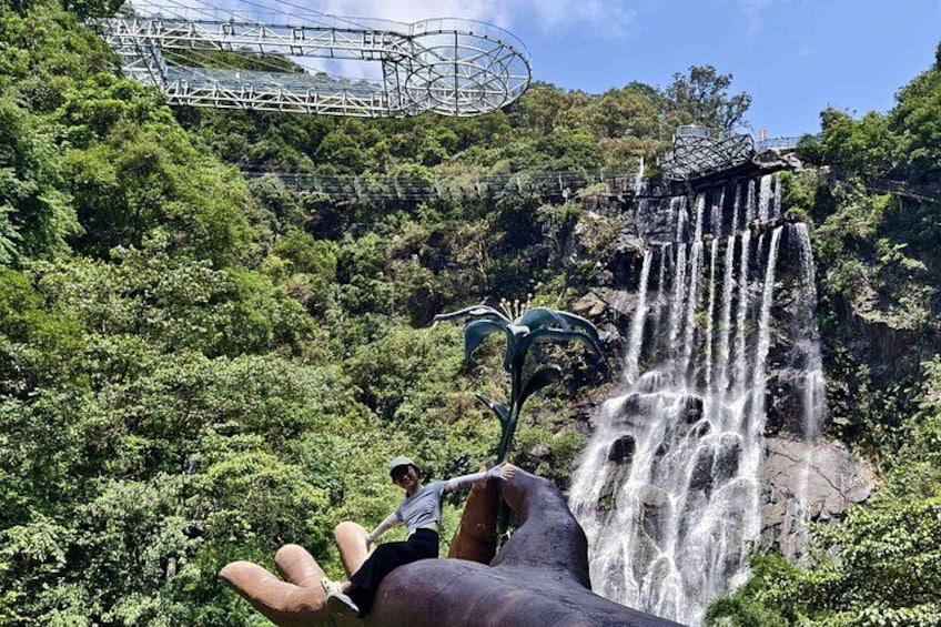 A waterfall, lush greenery, and a roller coaster in the background. 4