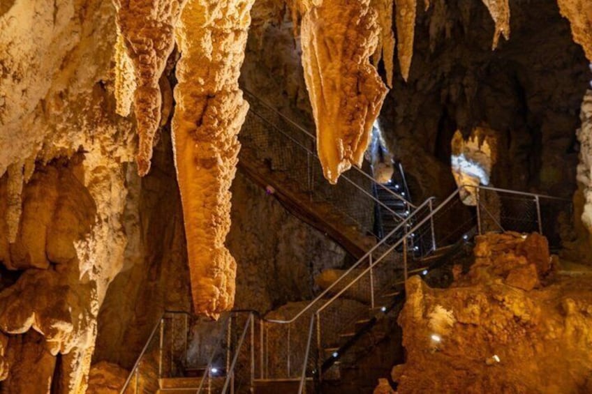 Eine Höhle mit Stalaktiten, einer Treppe und einem Metallgeländer. 2