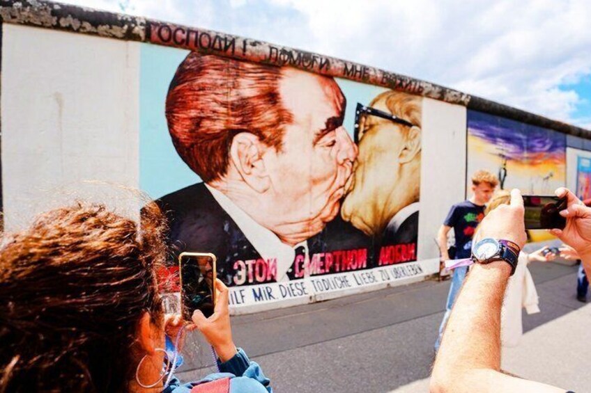 A mural on a wall with a person taking a photo. 2