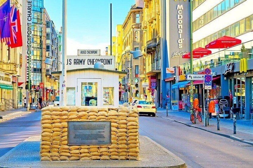 A street with a memorial plaque, a McDonald's sign, and a taxi stand. 4