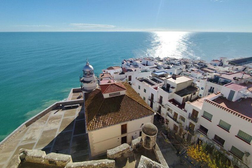 Un pueblo costero con edificios blancos, un faro y el mar. 3