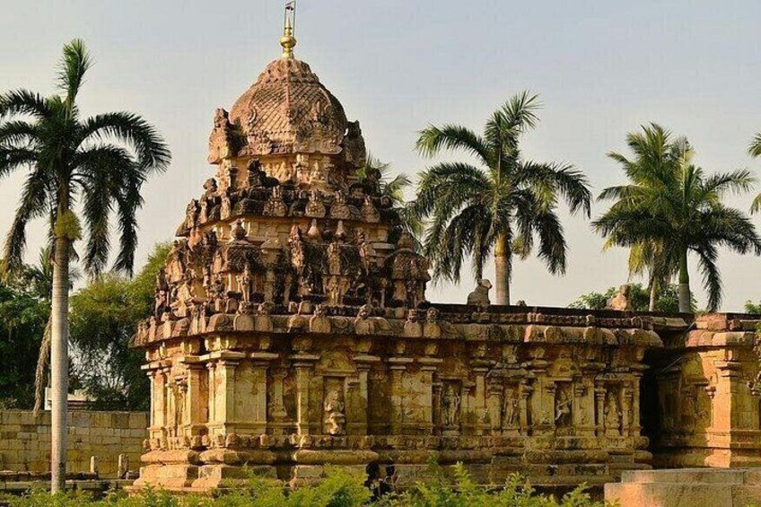 A temple with intricate carvings, a large dome, and palm trees in the background. 4