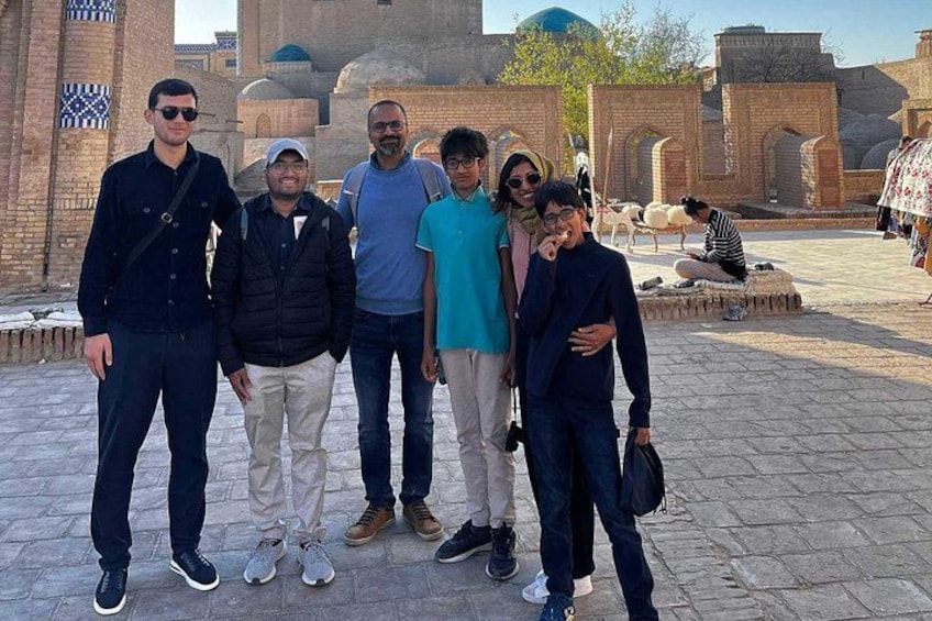 A group of people standing in front of a historical building with arches and domes. 4