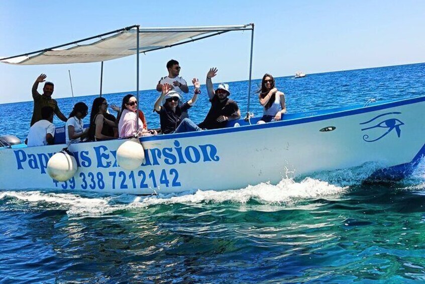 Un bateau rempli de passagers qui agitent les bras, portant l’inscription « Excursion de Papaya » et affichant un numéro de téléphone. 3
